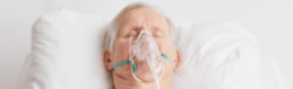 Ein Mann trägt eine Sauerstoffmaske, die mit einem Sauerstoffschlauch versehen ist